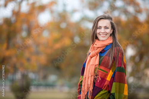 Autumn woman with in autumn colors clothes walking in park
