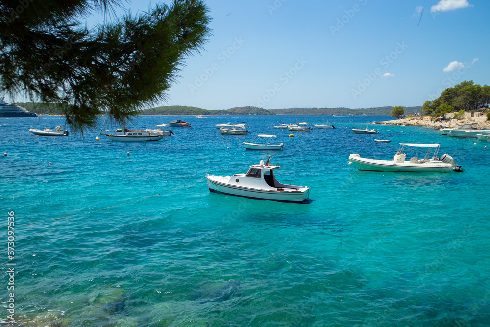 Beautiful dalmatian sea off the coast of Hvar island, full of small, white boats anchored in the Majerovica bay