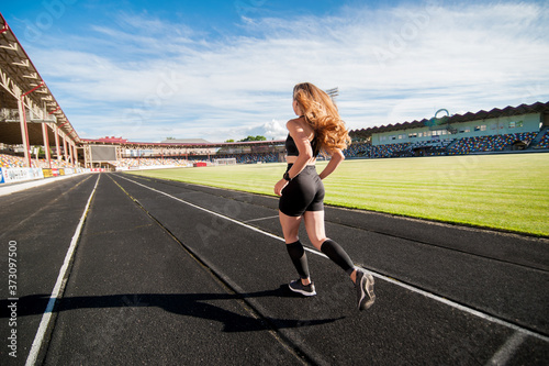 young, athletic girl running on the track © pavlobaliukh