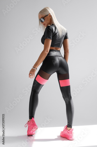 Fototapeta Naklejka Na Ścianę i Meble -  Sexy fitness woman. Beautiful athletic girl, isolated on the gray background