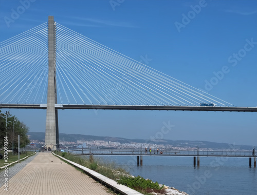 Walking the footpath Passeio do Tejo along Tagus river in Lisbon at the Expo park - Vasco da Gama bridge