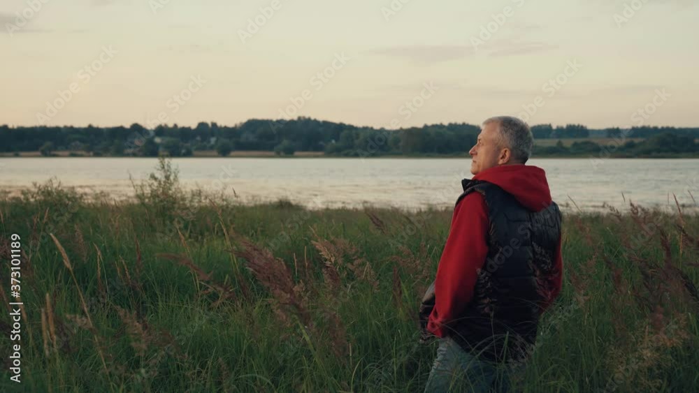 A man stands on the Bank of a river at sunset. A man stands on the Bank of a river at sunset.