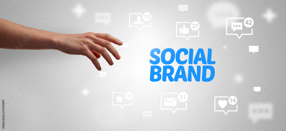 Close-Up of cropped hand pointing at SOCIAL BRAND inscription, social networking concept Close-Up of cropped hand pointing at SOCIAL BRAND inscription, social networking concept