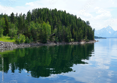 View of mountain peaks reflecting in water in summer in Grand Teton National Park in Wyoming, United States