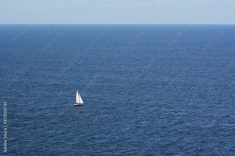 Fototapeta premium A lonely sailing boat against the blue sea. Mediterranean Sea, Europe