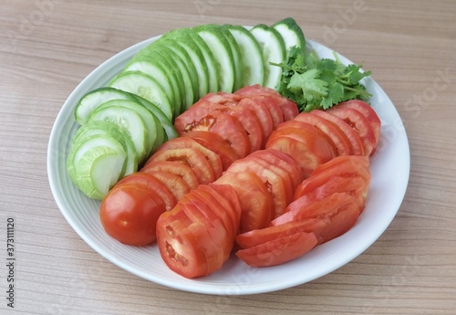 Slice Tomatoes, Cucumbers with Corianders on Dish