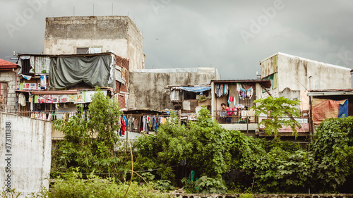 Manila, Philippines - A squatter area in Manila with vegetation and trees in front. photo