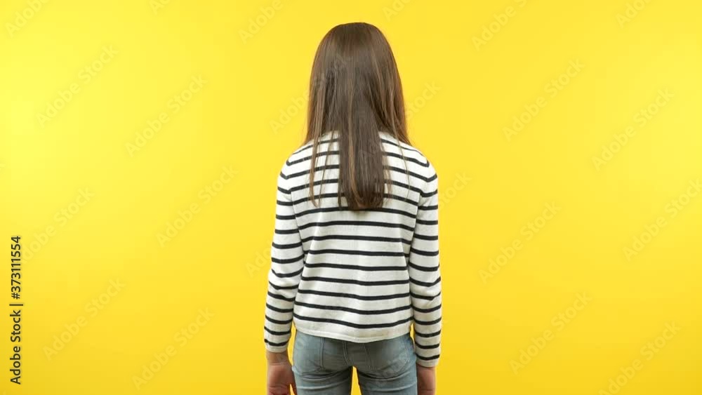 Funny little child girl from behind, looking back