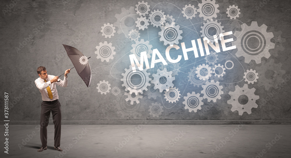Businessman defending with umbrella from MACHINE inscription, technology concept Businessman defending with umbrella from MACHINE inscription, technology concept