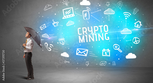 Businessman defending with umbrella from CRYPTO MINING inscription  modern technology concept