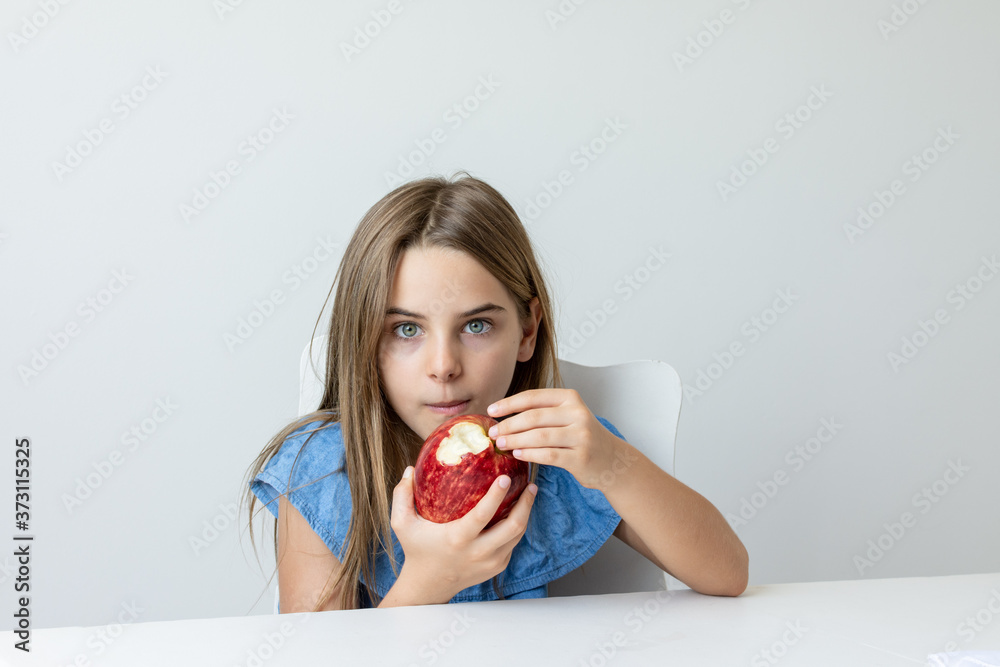 Criança feliz se deliciando com maça saborosa e fazendo caretas Criança feliz se deliciando com maça saborosa e fazendo caretas