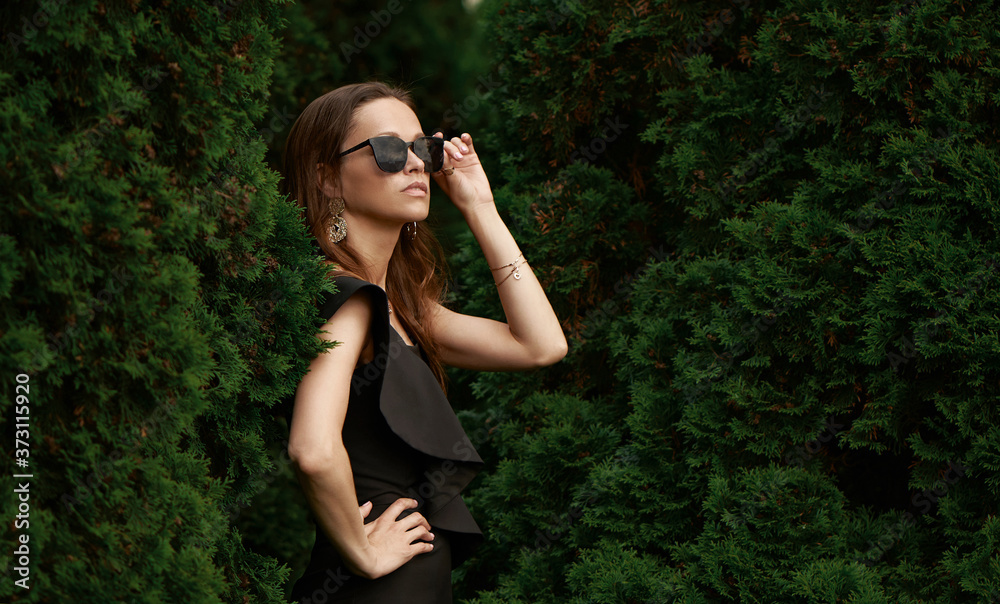 Fashionable beautiful woman is wearing sunglasses in the park Fashionable beautiful woman is wearing sunglasses in the park