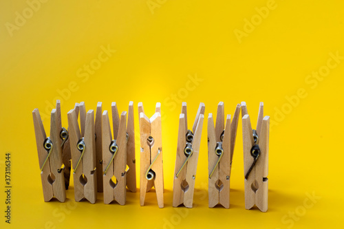Wooden clothespins standing on a yellow background. The concept of success and development. Business