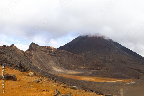 Mountain View & Yellow Earth. Volcanic Rock Hills. Fog on Mountains, Cloud and Blue Sky Background. Trekking, Hiking & Climbing Image. Natural Mystic Scene and Adventure Landscape.