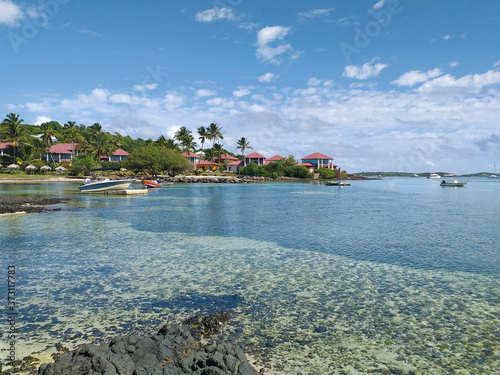 Fototapeta Naklejka Na Ścianę i Meble -  Spectacular tropical landscape with Caribbean houses and calm turquoise waters of the Caribbean Sea. Idyllic background of the French West Indies.