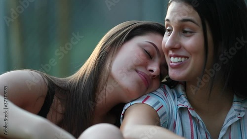 Lesbian couple together outdoors. Friend leaning on partner shoulder for support. Candid and authentic LGBT lovers photo