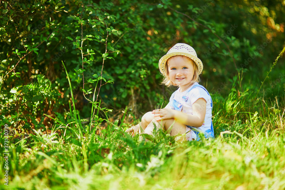 Adorable toddler girl having fun outdoors on a sunny summer day Adorable toddler girl having fun outdoors on a sunny summer day
