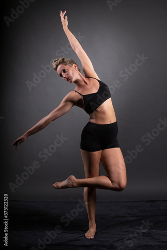 Ballerina dance in studio, black background