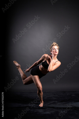 Ballerina dance in studio, black background