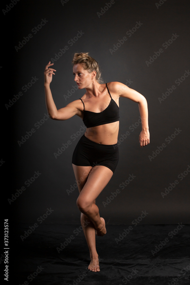 Ballerina dance in studio, black background