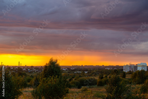 Very beautiful sunset in the city or village. Pink-orange sky with clouds.
