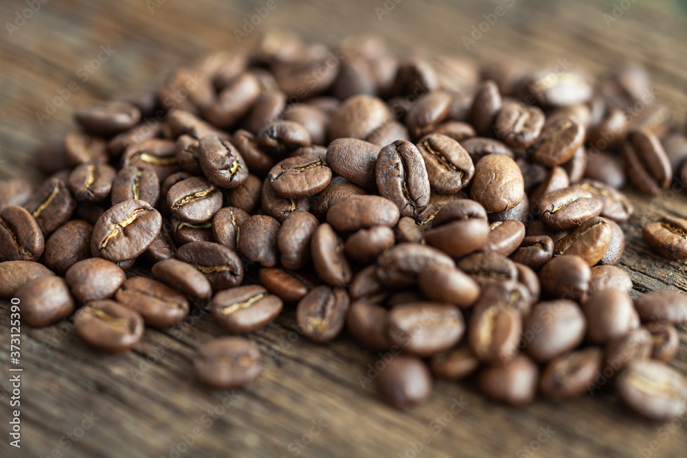 Fototapeta premium Close-up of coffee beans on a wooden table, macro shot