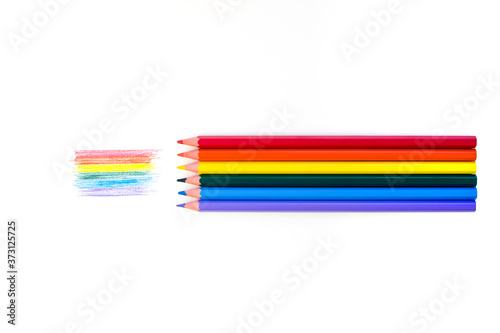 Lgbt rainbow flag on white background and colored pencils of all colors of the rainbow adjoining their color. View from above