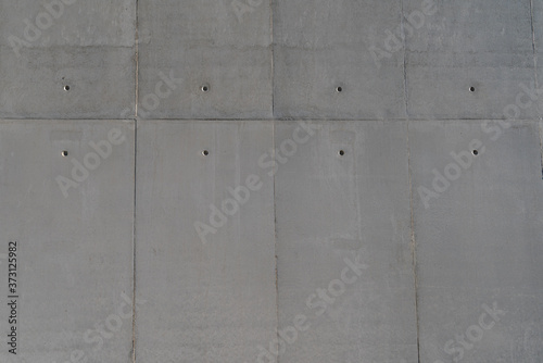 Close-up View of Fairfaced Insitu Concrete Building Wall With Boltholes and Board Marks, Straight-on view of solid smooth textured surface with horizontal and vertical lines and dot marks 