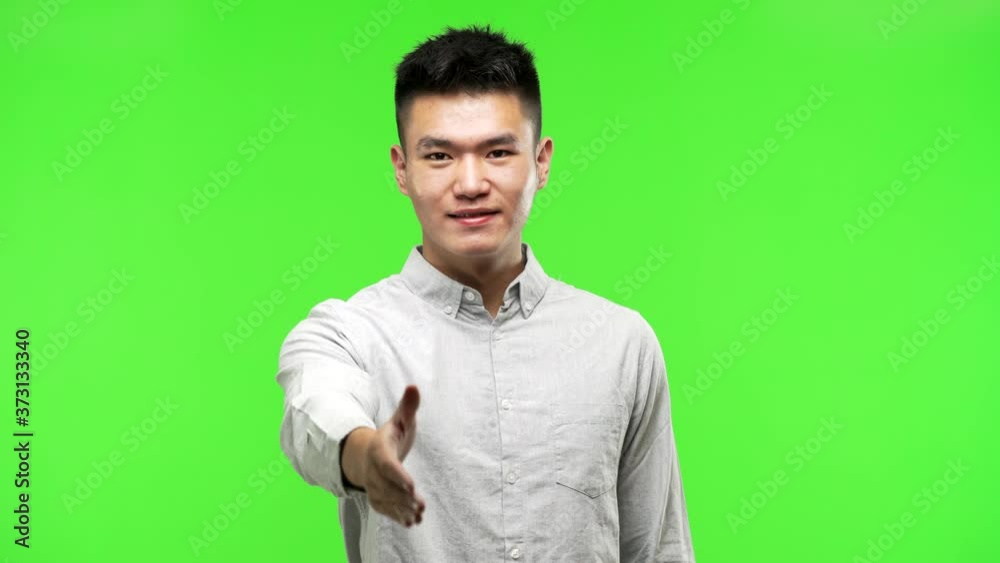 Young handsome chinese man reaching out to greet someone Young handsome chinese man reaching out to greet someone