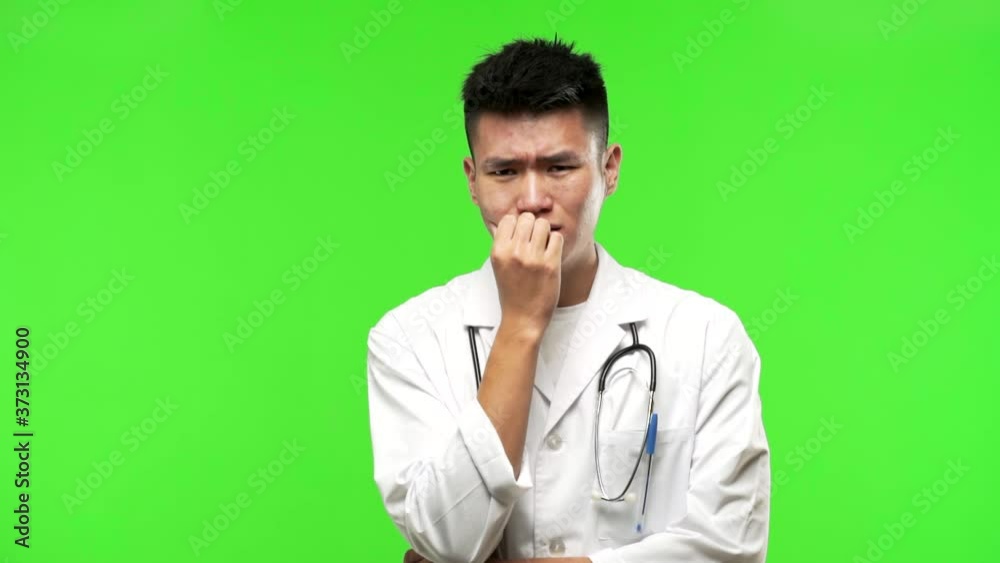 Young chinese doctor man biting nails, nervous and very anxious Young chinese doctor man biting nails, nervous and very anxious