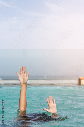 Women's hands coming out of the pool water.