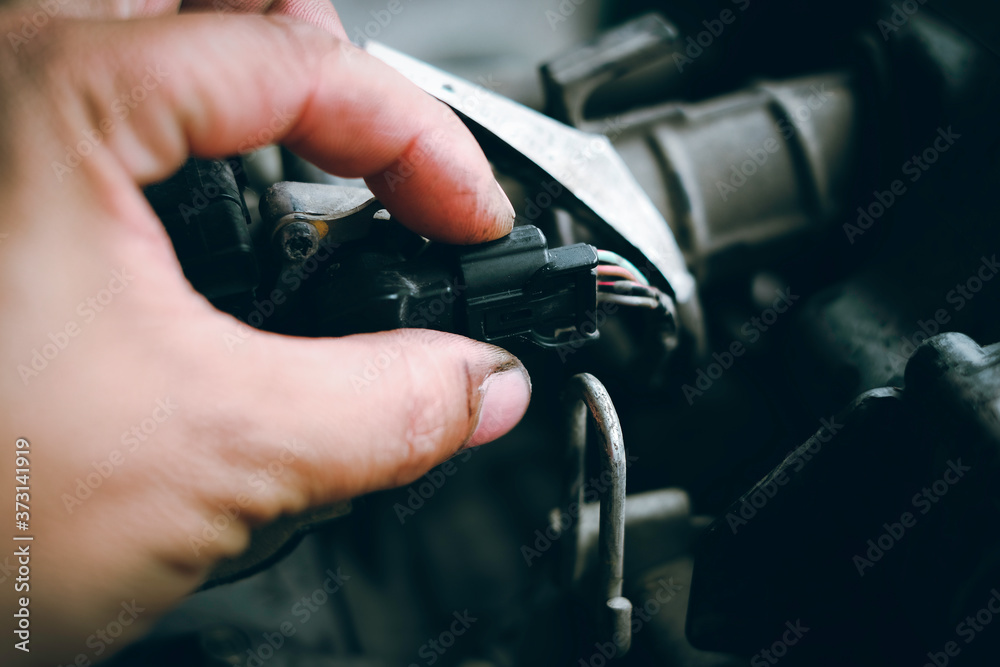 Mechanic inspecting electrical wires on motorcycles or checks.