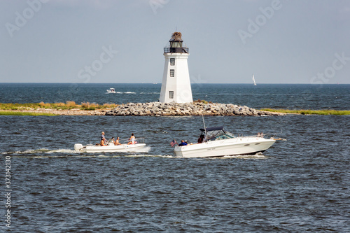 Fayerweather Lighthouse with two power boats passing by in Bridgeport, Connecticut.