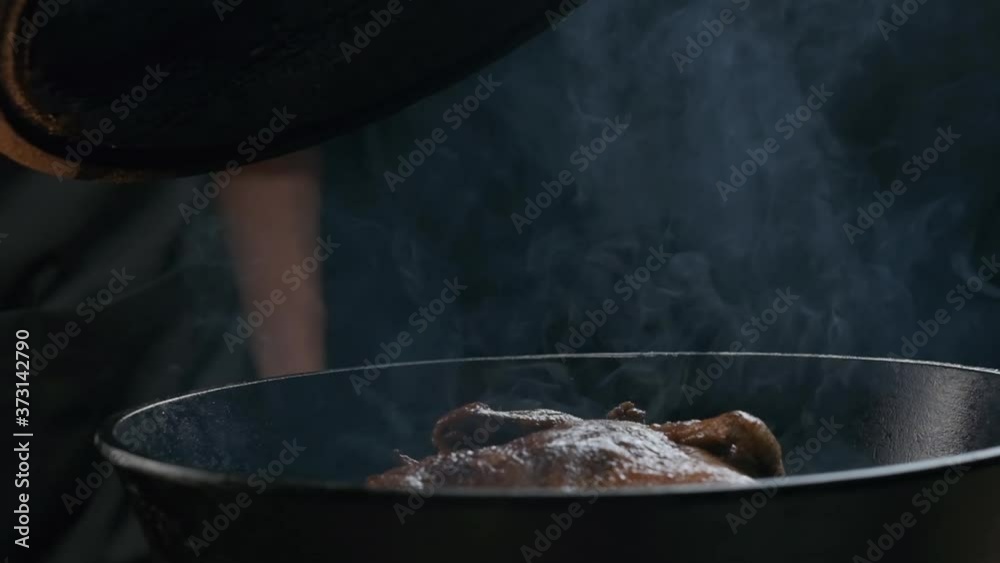 the chef removes the lid from the steaming grill, slow motion the chef removes the lid from the steaming grill, slow motion