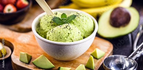 Homemade organic green avocado ice cream ready to eat, with mint leaf decorating.