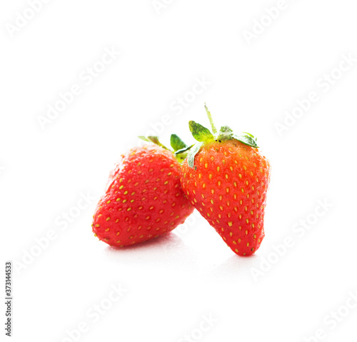 Two red fresh strawberries on a white background, close-up