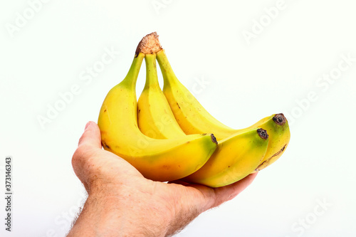 Mans hand holding a bunch of bananas isolated on a white background