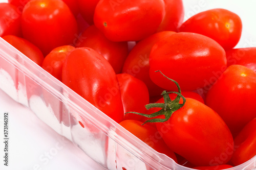 Tableau sur toile Baby plum tomatoes in a plastic punnet isolated on a white background
