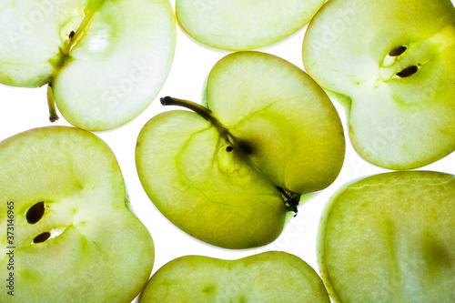 Slices of apple at the backlight isolated on a white background, macro photo