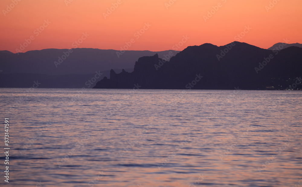 Beautiful view of the sea and the silhouette of Mount Karaul-Oba at sunset