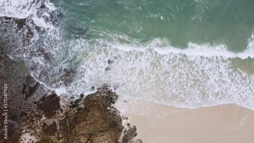Aerial view of turquoise sea with wave moving to rock beach. Aerial view of turquoise sea with wave moving to rock beach.