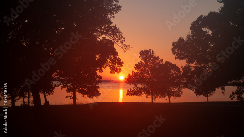 Sunset on the lake with trees in silhouette