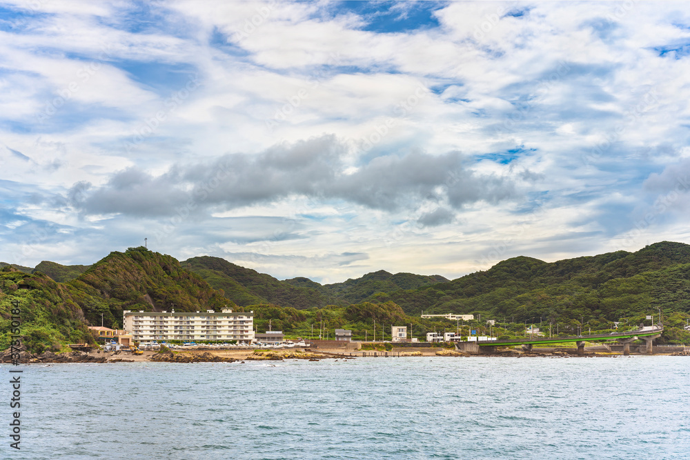 Naklejka premium Coast of the Kanaya Marina along the Uraga Channel with the loop ramp of the Futtsu Kanaya Interchange in front of the Mount Nokogiri in the Bōsō Peninsula.
