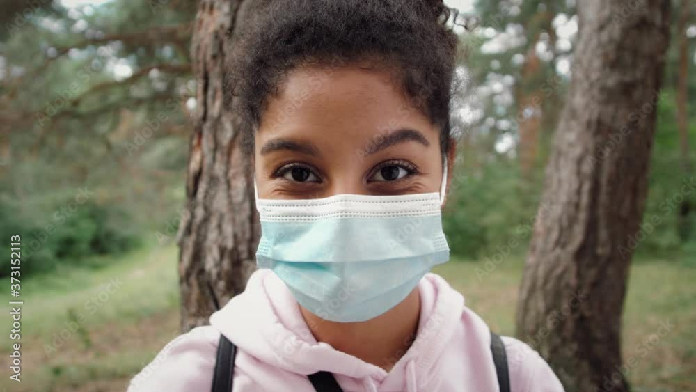 Gorgeous dark skinned black young woman with Afro hairstyle wearing protective mask against COVID virus, afrrican american girl with medical mask, public space post covid, safe travel after pandemic Gorgeous dark skinned black young woman with Afro hairstyle wearing protective mask against COVID virus, afrrican american girl with medical mask, public space post covid, safe travel after pandemic