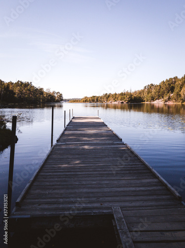 Wooden board walk or jetty in  a lake near a bathing place in s´gothenburg sweden , No people because of COVID © joisbalu