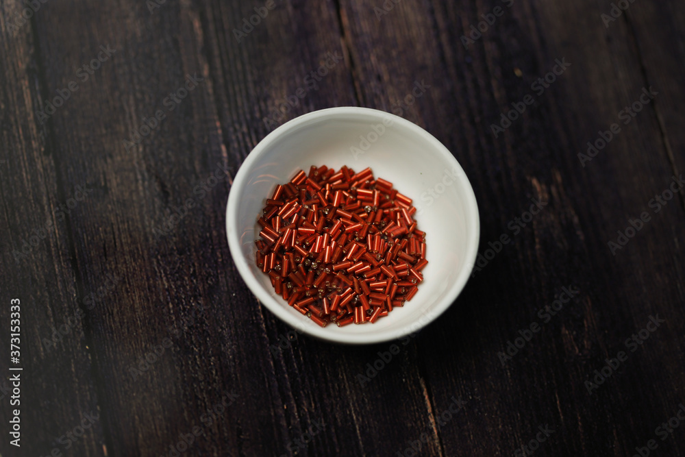 Orange bugles in white cup on black background Orange bugles in white cup on black background