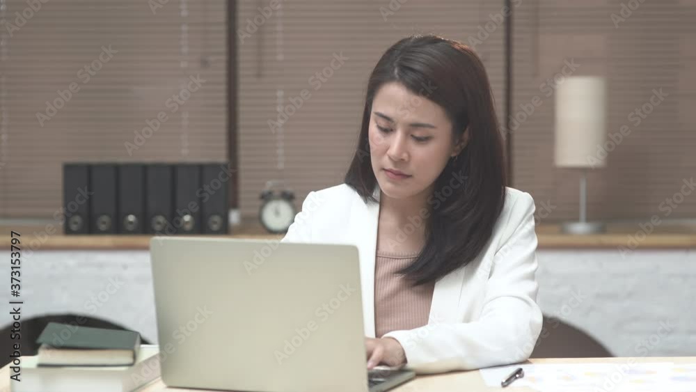 Young pleased happy cute business woman sit indoors in office using laptop talking to computer by video conference call Young pleased happy cute business woman sit indoors in office using laptop talking to computer by video conference call