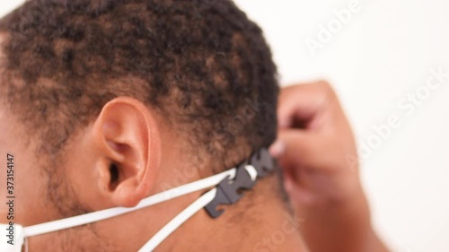 Black man putting on Mask Ear Strap Hook Face Mask Adjustable Ear Loops