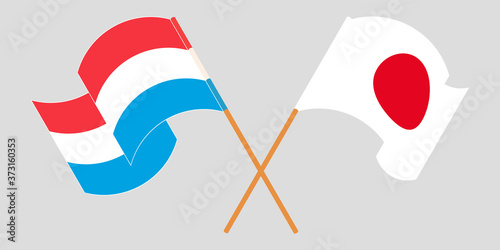 Crossed and waving flags of Luxembourg and Japan