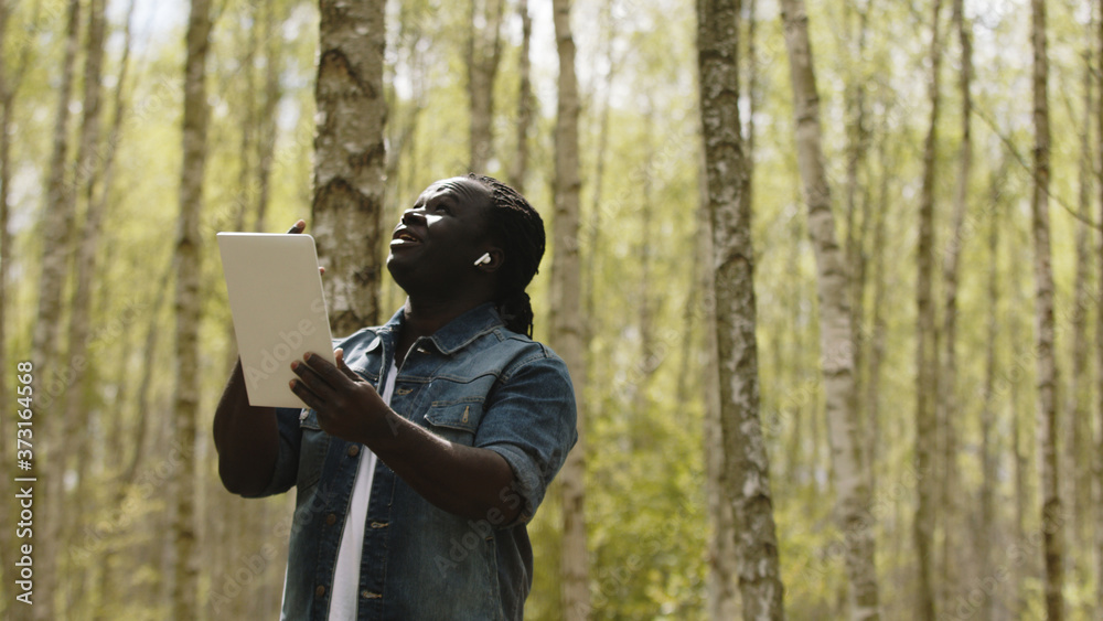 An african man using the tablet in the forest. wireless or future technology concept. High quality photo An african man using the tablet in the forest. wireless or future technology concept. High quality photo